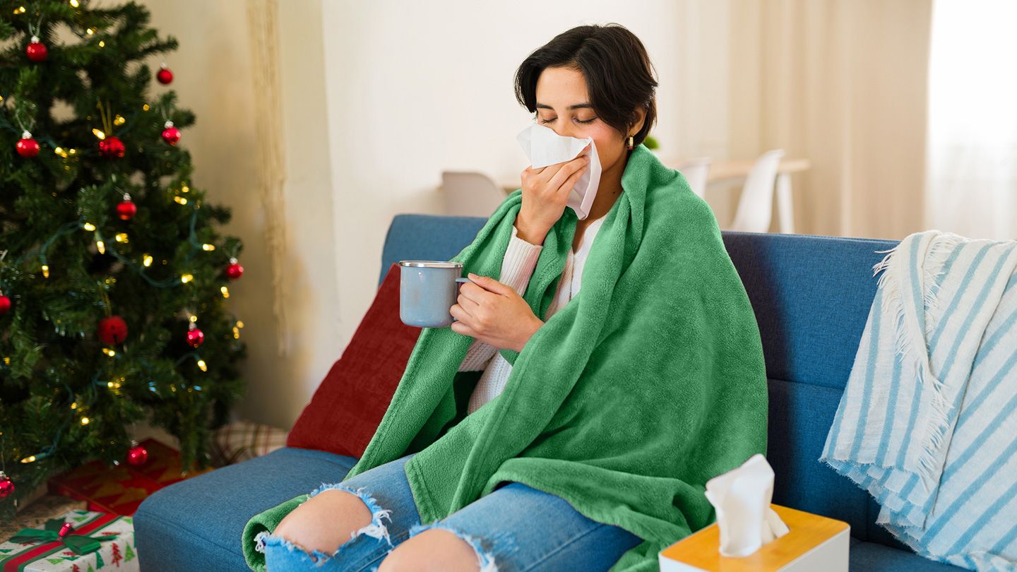 woman with allergies on couch with tissues and mug